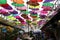 Street installation with colorful, beautiful umbrellas floating in the air against the sky.