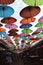 Street installation with colorful, beautiful umbrellas floating in the air against the sky.