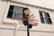 Street lamp with flower pots on house facade in Hamilton, Bermuda. Potted flowers on lighting column with stree lamp