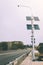 Street lamp poles powered by solar energy. Solar panels on electric pole for lighting on the road in the city on the bridge