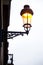 Street lamp post with light turn on during day time depicts concept of energy waste