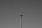 Street lamp post standing alone on the sky background black and white