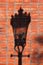 Street lamp shadow on a red brick wall.