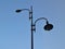 Street lamp with two lights against a blue sky, bottom view