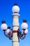 Street lamp with white shades on the background of blue sky