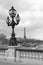 Street lantern on the Alexandre III Bridge with Eiffel Tower in Paris, France, monochrome