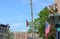 Street light and pole with winged animals on brick building and flags