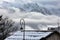 Street Lighting over snowed roof in village situated on slope of mountain .