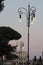 Street lights near colosseum at sunset in Rome Italy.