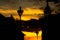 Street lights and silhouettes of historical buildings against an orange sky at twilight time in Oradea, Romania