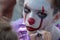 Street makeup. The image of a clown or mime. Costume for carnival or holiday halloween. Cosplay at a horror party. Artist`s hand