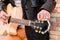 Street musician close up tuning the guitar. Fingers turning the tuning pegs of an acoustic guitar