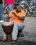 Street musician with orange shirt playing the Djembe