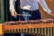 Street musician performs a melody on xylophone. Artist hands with sticks, wooden sounds