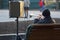 Street musician sitting on the bench and plays the trumpet