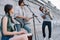 Street musicians band performing with guitar drum and saxophone on sunny