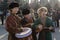 Street musicians in national costumes play folk instruments - a drum and a dombra during a holiday