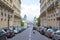 Street in Paris with perspective, man and woman riding moped in France