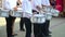 Street performance of festive march of drummers boys in costumes on city street. Close-up of boy`s hand drummers are