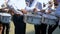 Street performance of festive march of drummers boys in costumes on city street. Close-up of boy`s hand drummers are