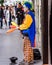 A street performer is dressed as a clown and juggling pins