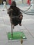 Street performer stays in midair only hanging to a small pole.