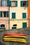 Street photo of house and colorful boats on wall. Manarola. Liguria, Italy.