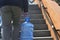 Street photo. Rear view of a man carrying a plastic bottle of drinking water.