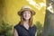 Street portrait of a 35-40-year-old woman in a summer straw hat on a neutral background, a flirtatious and playful smile, a myster