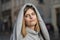 Street portrait of a beautiful young and cheerful woman 25-30 years old with blonde hair and a gray hoodie against the background