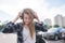 Street portrait of a girl in casual clothing, walking around the city with headphones and listening to music