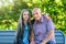 Street portrait of granddad and granddaughter sitting on wooden bench