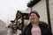 Street portrait of merry young woman wearing stylish knitted hat