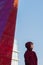 Street portrait of teenage boy wearing dark red hooded sweatshirt at glass high-rise building background