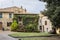 Street with pots of flowers, road sign, lawn and bench in Montalcino, Tuscany, Italy