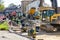 Street reconstruction site with several excavators, vibratory plate compactors and other machinery