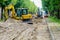 Street reconstruction view with several excavators and other machinery, dismantled street surface