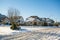 Street of residential houses in snow on winter sunny day