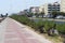 Street, road, bushes with flowers along the road in the resort Turkish town, buildings on a summer day