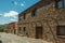 Street with rustic houses and stone walls with plants