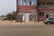 Street scene in the city of Bissau, with people in a sidewalk passing in front of a store, in the Republic of Guinea-Bissau