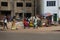 Street scene in the city of Bissau with people walking in a sidewalk and street vendors selling fruit, in Guinea-Bissau