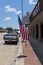 Street scene in the city of Giddings along the Highway 290 with a parked pickup truck and the American Flag in Texas