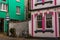 Street in a seaside town, with colorful facades of buildings, en