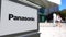 Street signage board with Panasonic Corporation logo. Blurred office center and walking people background. Editorial 3D