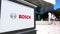 Street signage board with Robert Bosch GmbH logo. Blurred office center and walking people background. Editorial 3D