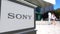 Street signage board with Sony Corporation logo. Blurred office center and walking people background. Editorial 3D