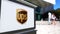 Street signage board with United Parcel Service UPS logo. Blurred office center and walking people background. Editorial
