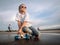 Street sports: Jolly Girl in sunglasses sat down to relax on the longboard after a walk in the park for skating.