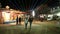 Street with stands in night time in Jodhpur with people passing.